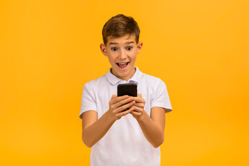 Surprised and thrilled teen boy looking at smartphone screen