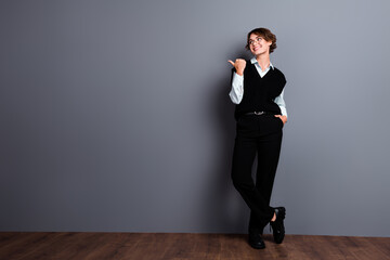 Fototapeta na wymiar Full length photo of good mood dreamy woman broker wear waistcoat spectacles pointing finger empty space isolated grey color background