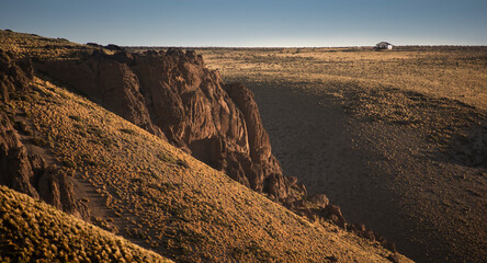 little house in landscape with a big cliff in patagonia argentina, neuquen