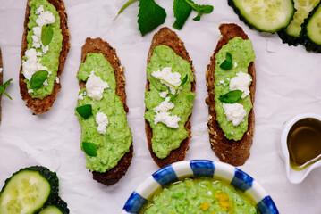 Green pea dip with feta and crostini. top view .