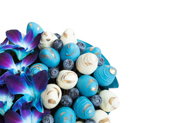 Fresh strawberry covered by blue and white chocolate with berries and orchid designed as bouquet.