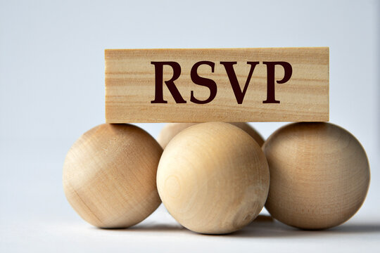 RSVP - words on a wooden block on a white background with wooden balls