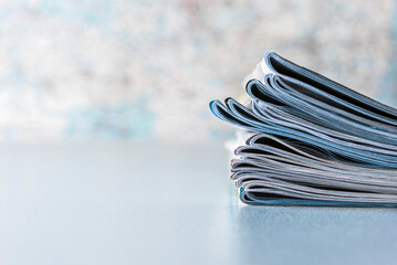 Stack of newspapers lying on the table with blurred background