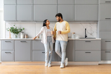 Cute loving young indian man and woman drinking coffee together