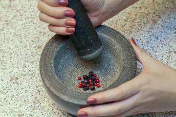 Stone Grinder Bowl. Woman Hands Grinding Pepper In Stone Mortar.
