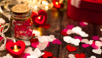 Valentine composition with hearts and gift box on wooden background