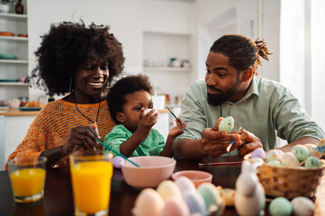 Fototapeta na wymiar Portrait of a happy african american family painting easter eggs