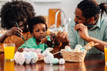 African american family having fun decorating easter eggs together at home - obrazy, fototapety, plakaty
