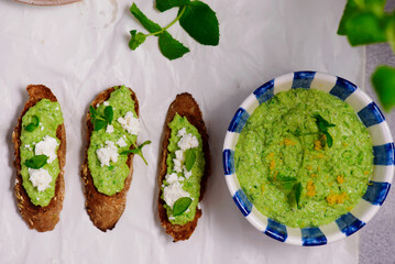 Green pea dip with feta and crostini. top view .
