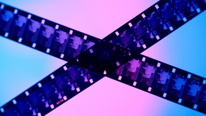 Crossed stripes of photographic film on blue background close up. Negatives of photographic film...