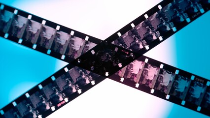 Crossed stripes of photographic film on blue background close up. Negatives of photographic film...