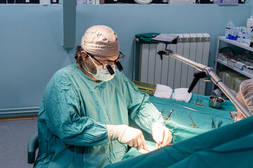 Skilled surgeon performs a precise operation in a sterile operating room.