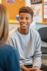 Psychologist communicating with a teenage boy in school office - obrazy, fototapety, plakaty