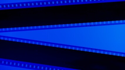 Two black film strips on blue background close up. 35mm film slide frame. Copy space.