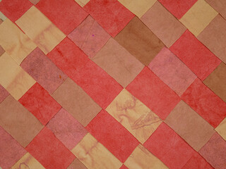 Handmade background in patchwork style with cotton fabric elements in red tones