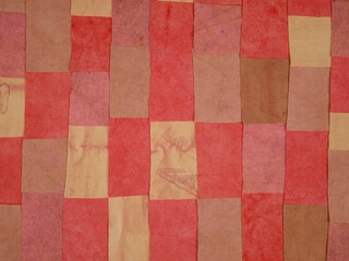 Handmade background in patchwork style with cotton fabric elements in red tones