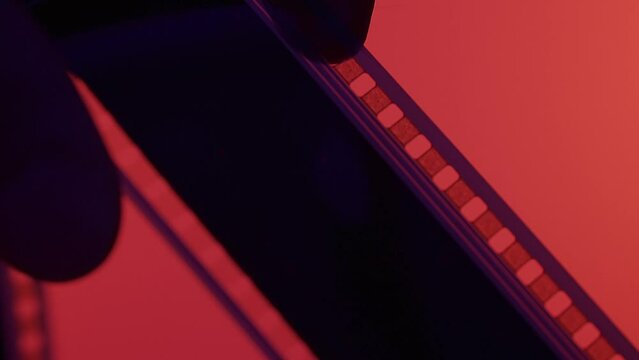 Silhouette of rewind film in darkness on red background close up. Retro film rewind to Finish caption in the frame.