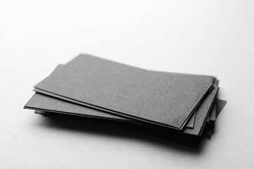 Blank black business cards on light background, closeup. Mockup for design