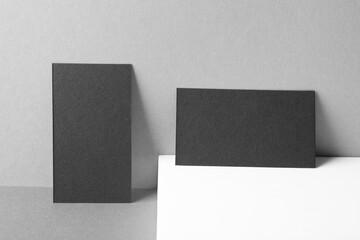 Blank black business cards on grey background. Mockup for design