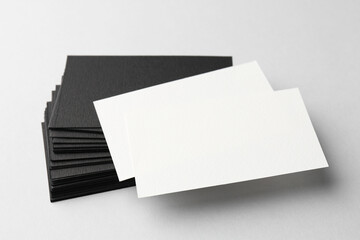 Blank black and white business cards on light background, closeup. Mockup for design