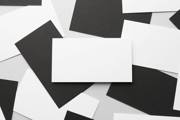 Blank black and white business cards on light background, flat lay. Mockup for design