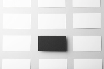 Blank black and white business cards on light background, flat lay. Mockup for design