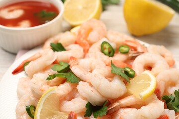 Tasty boiled shrimps with cocktail sauce, chili and parsley on table, closeup