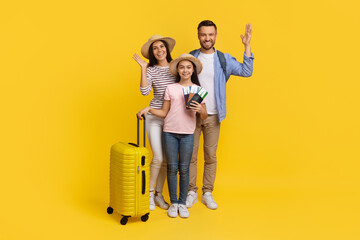 Happy caucasian family with suitcases and travel documents posing on yellow background - obrazy, fototapety, plakaty