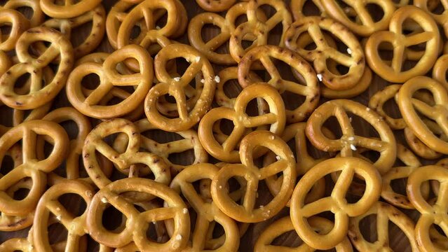 Crispy salted baked mini pretzels background, close up, rotation, slow motion. Cracker cookies with salt as a beer snack
