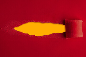 Red construction paper torn in the middle with a yellow background inside