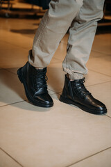 The image is a close-up of a person's legs wearing black boots 5937.