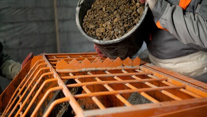 Loading crushed stone into a mixer for construction screed. Crushed stone is poured from a bucket...