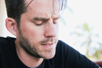 Close up portrait of a man being sad and frustrated, sitting outside 
