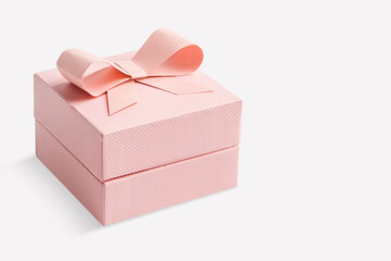Pink box with a bow on an light  background.