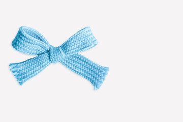 Blue bow made of thick knitted material on a light  background