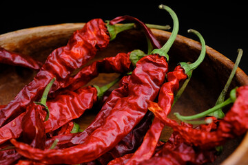 Organic dried red hot peppers in a wooden plate