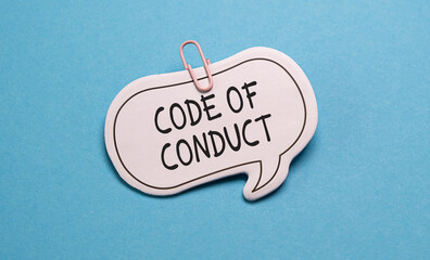 Whiteboard with Code of Conduct written in black marker against a blue background