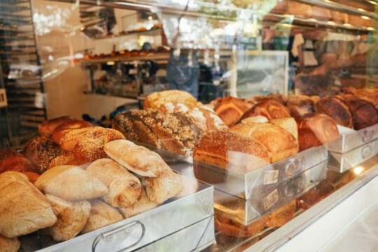 Fresh bread rolls, bagels, loafs on a vitrine of a bakery 
