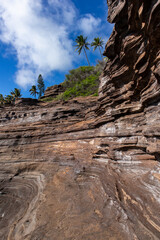 Vertical shot of a layered cliff of volcanic rock in O'ahu, Hawaii - obrazy, fototapety, plakaty