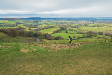 backpacker hiker on the high ground of Coaley Peak, Stroud, Gloucestershire, UK