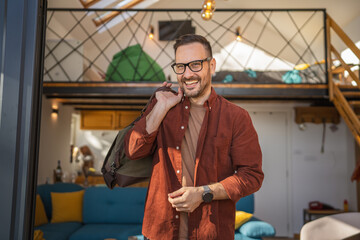 Portrait of one man happy caucasian male with travel bag at his house
