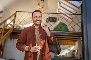Portrait of one man happy caucasian male with travel bag at his house