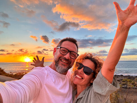Happy adult traveler enjoy sunset in tropical destination beach together having fun and taking selfie picture to share on social media. Traveler influencer lifestyle. People summer holiday vacation