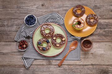 Fresh apples with nut butters, blueberries, chocolate chips and nuts on wooden table, flat lay