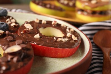 Fresh apples with nut butter, chocolate chips and nuts on table, closeup