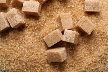 Different types of brown sugar as background, top view