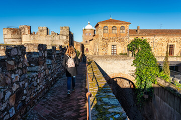 Tourist woman strolling over the wall of the medieval city of Caceres.