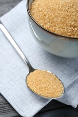 Brown sugar in bowl and spoon on table, closeup
