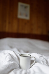 Fototapeta na wymiar Morning Comfort: A Warm Cup on a Cozy Bed
