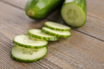 Cut ripe cucumber on wooden table, closeup